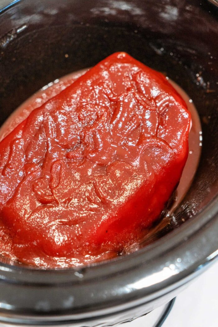 This simple 2-ingredient recipe features succulent roast beef simmering in a red sauce, creating tender bites reminiscent of pulled pork, all brought together effortlessly in a slow cooker.