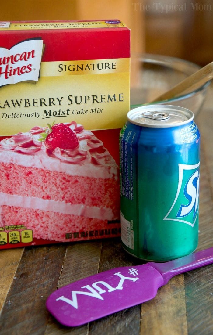 A box of strawberry cake mix and a can of Sprite sit beside a purple spatula on the counter, ready for an easy 2 ingredient strawberry cake.