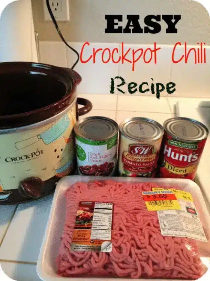 A photo showing ingredients for a 5 ingredient Crockpot chili recipe. Includes a Crockpot, a pack of minced meat, a can of tomato sauce, a can of diced tomatoes, and a can of dark red kidney beans. Text at the top reads "EASY Crockpot Chili Recipe.