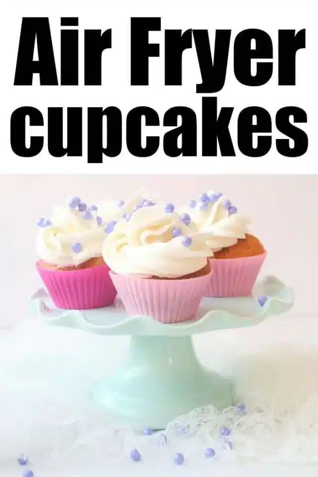 A display of three Air Fryer cupcakes with white frosting and purple sprinkles on a light blue cake stand. The cupcakes are in pink wrappers. The text above reads "Air Fryer Cupcakes.