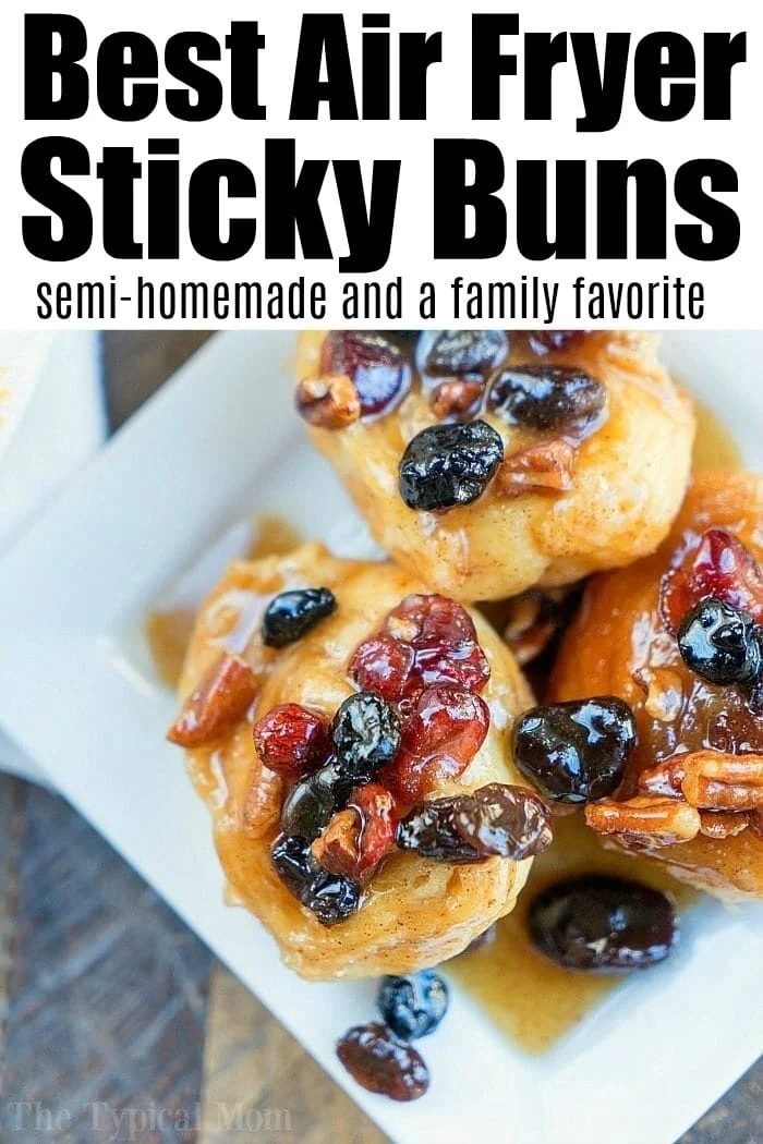 Three sticky buns topped with nuts and dried fruit on a white plate, viewed from above—solid inspiration for air fryer dessert recipes.