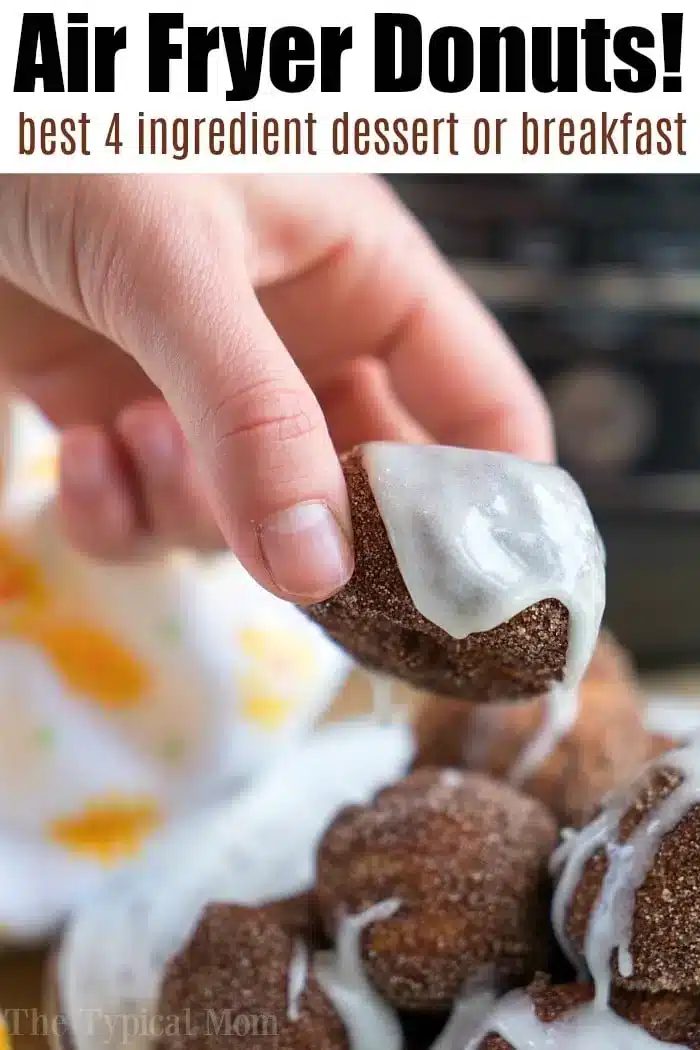 Hand dipping a chocolate donut with white glaze; try air fryer dessert recipes—best 4 ingredient treat!.