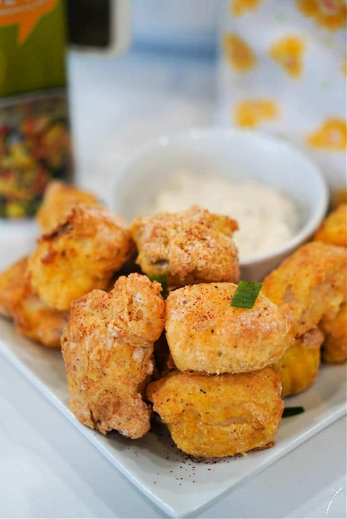 A plate of crispy, breaded chicken nuggets sits beside a bowl of dipping sauce, solid for snacking—try swapping in air fryer fish nuggets for a tasty twist.