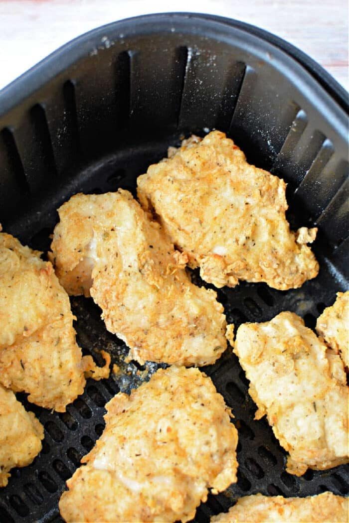 Golden air fryer fried chicken breast pieces in a basket, crispy and ready to be served.
