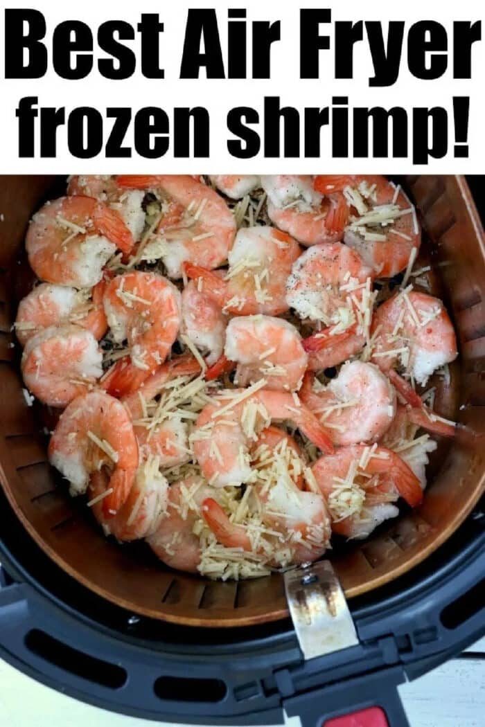 Air fryer basket filled with air fryer frozen shrimp, topped with shredded cheese and seasoning for a quick, good meal.