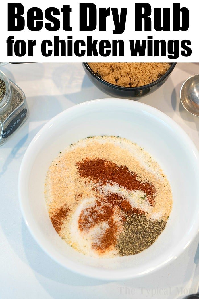 A white bowl brimming with spices for a dry rub, including brown sugar, paprika, and black pepper. Nearby sit a jar and bowl with similar ingredients. The text at the top reads, "Best Dry Rub for chicken wings," solid for your next air fryer wings recipe.