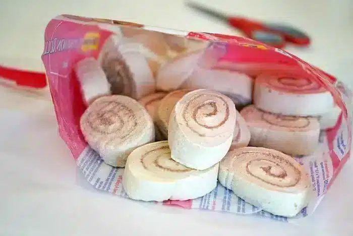 Open bag of packaged cinnamon swirl marshmallow snacks on a table, with scissors in the background—solid for pairing with homemade monkey bread muffins.