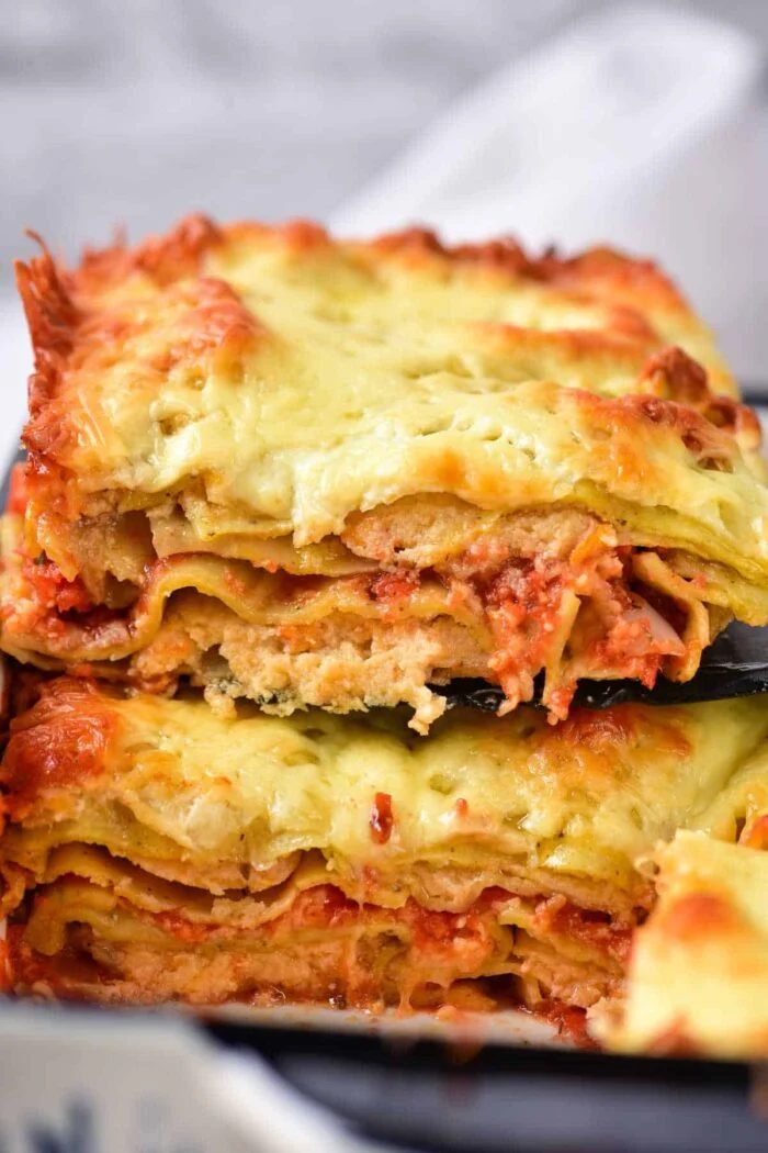 Two slices of cheesy, baked lasagna with layers of pasta, tomato sauce, and melted cheese—solid alongside our baked frozen ravioli for a comforting meal.