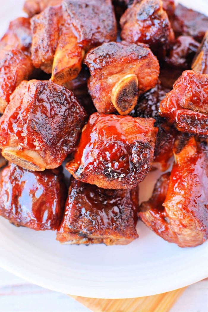 A plate of glazed barbecue sauce riblets stacked together, reminiscent of tender baked riblets in the oven.