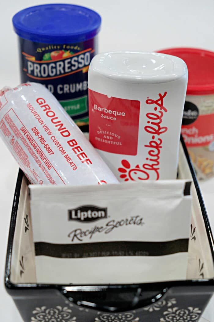A basket with ground beef, Chick-fil-A sauce, Lipton soup mix, bread crumbs, and cream of chicken soup—everything you need for a good BBQ Meatloaf Recipe.