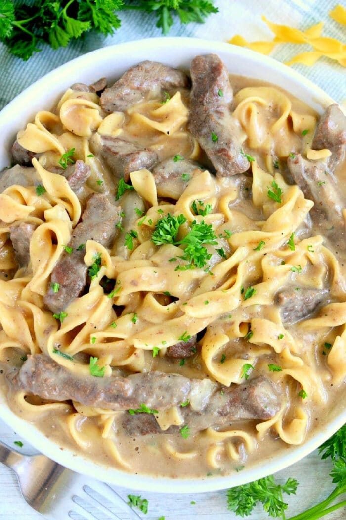 A bowl of creamy beef and noodles made effortlessly in the Instant Pot, garnished with parsley, featuring tender beef strips and perfectly cooked egg noodles.