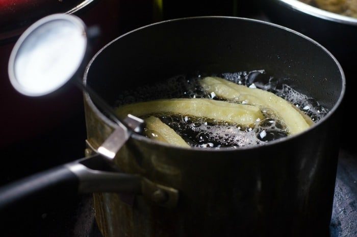 churros sizzle deliciously in a pot of oil on the stovetop, reminiscent of crafting the best churros recipe with care and attention.