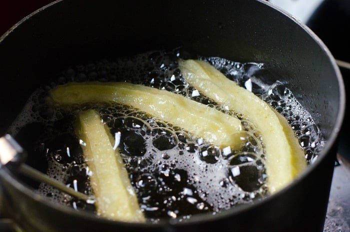 churros frying in hot oil inside a pan offer a delightful twist, reminiscent of the best churros recipe with their crispy, golden-brown texture.