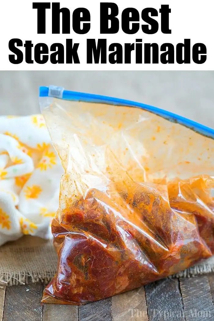 A plastic zipper bag filled with steak marinating in a red sauce sits on a wooden surface, promising the best fajita marinade experience. The text above reads "The Best Steak Marinade." A fabric with a floral pattern is partially visible on the left.