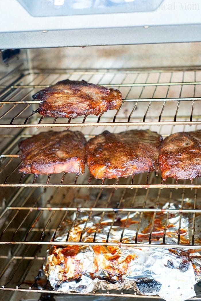 Smoked pork steaks and pork chops roast in electric smoker