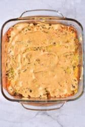 A square glass dish with a creamy Big Mac casserole sits enticingly on a marble surface.