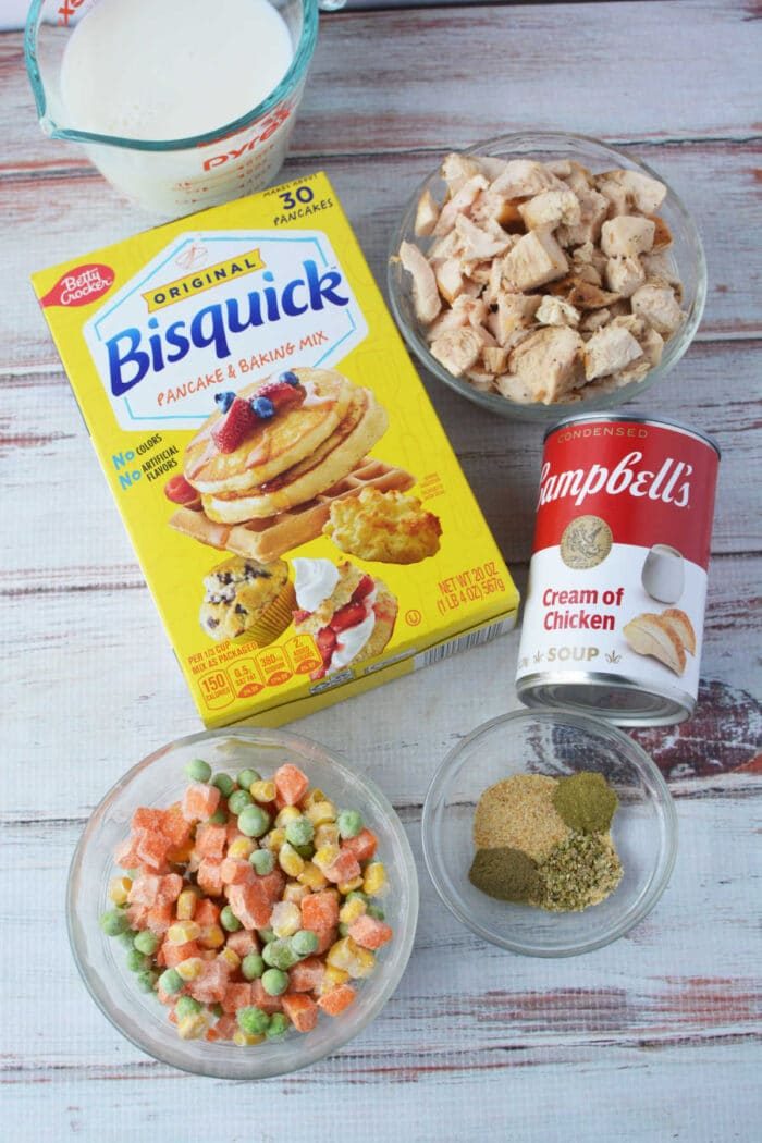 Bisquick chicken and dumplings made easy—combine Bisquick, milk, cooked chicken, cream of chicken soup, frozen veggies, and seasonings for a comforting classic on a wooden table.