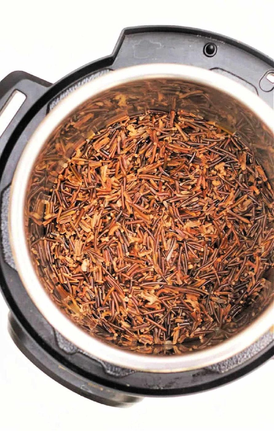 Cooked wild rice and black rice inside an Instant Pot, viewed from above on a white background.