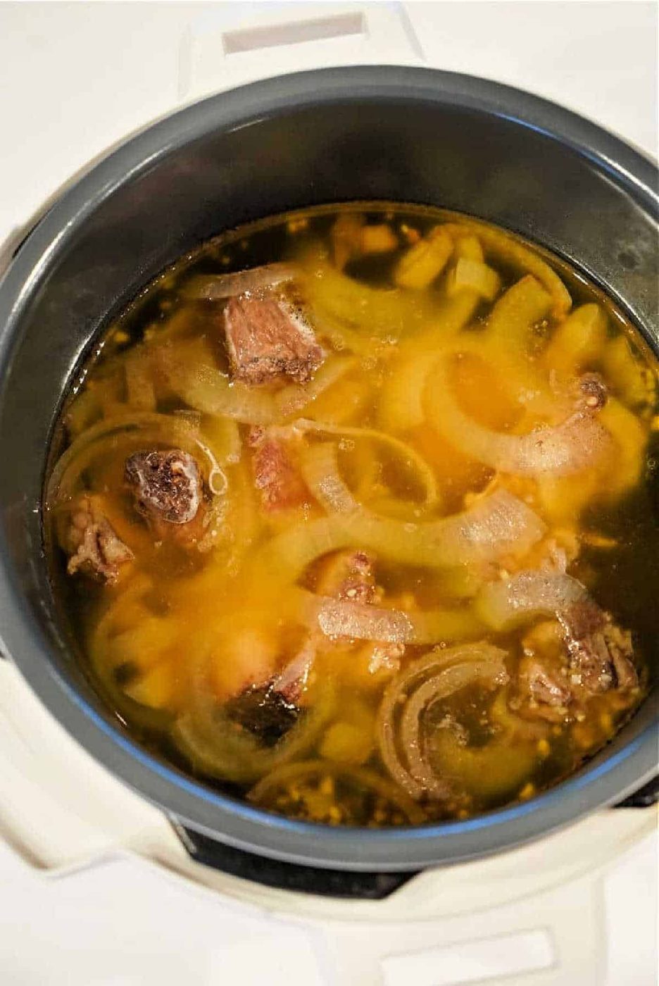 A pot of soup with meat chunks and sliced onions in a rich bone broth, solid for trying your favorite Bone Broth Recipe Instant Pot style.