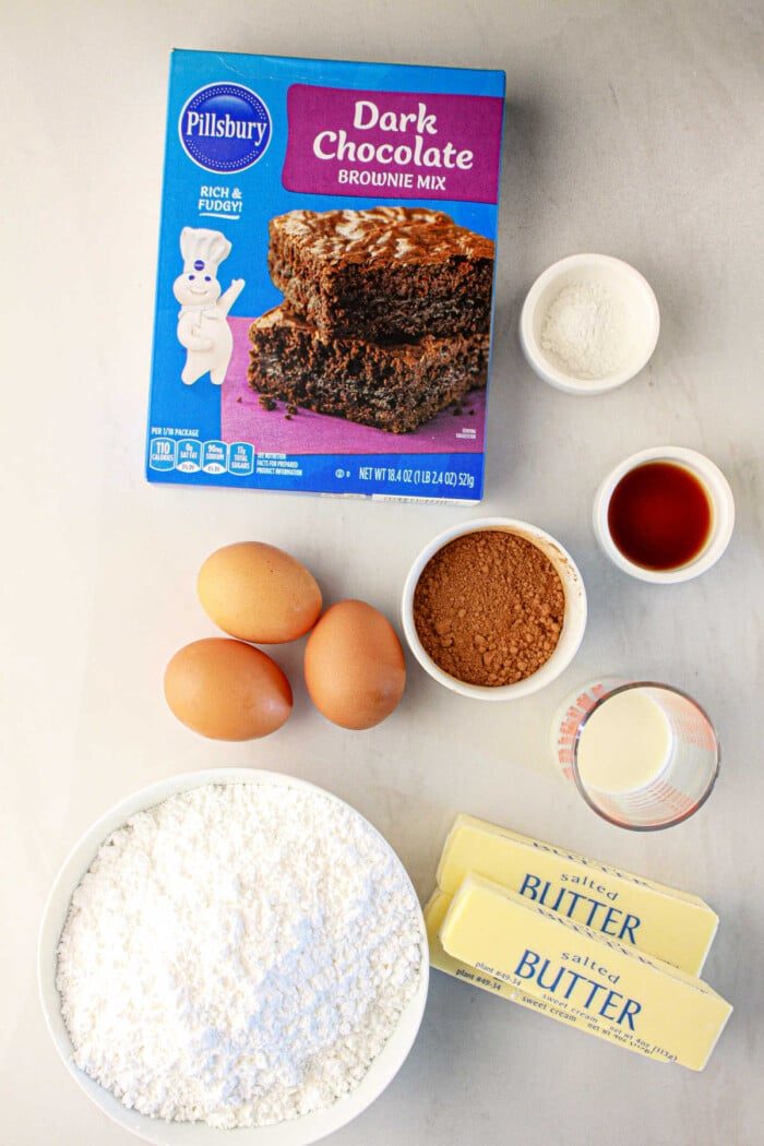 For good brownie cupcakes, gather baking essentials: brownie mix, eggs, butter, cocoa, flour, vanilla extract, and milk.