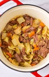 A delightful cabbage stew recipe featuring a pot filled with tender corned beef, savory cabbage, and vibrant carrots.