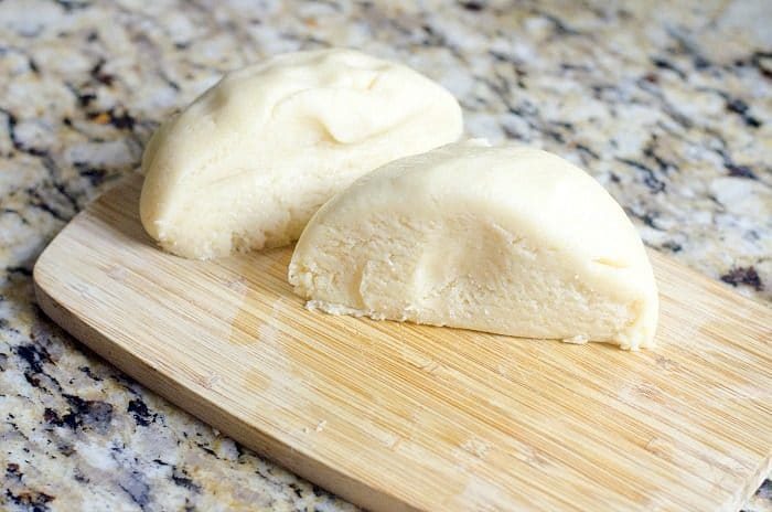Two halves of the beginnings of a crinkle cookies recipe, all placed atop a speckled countertop.