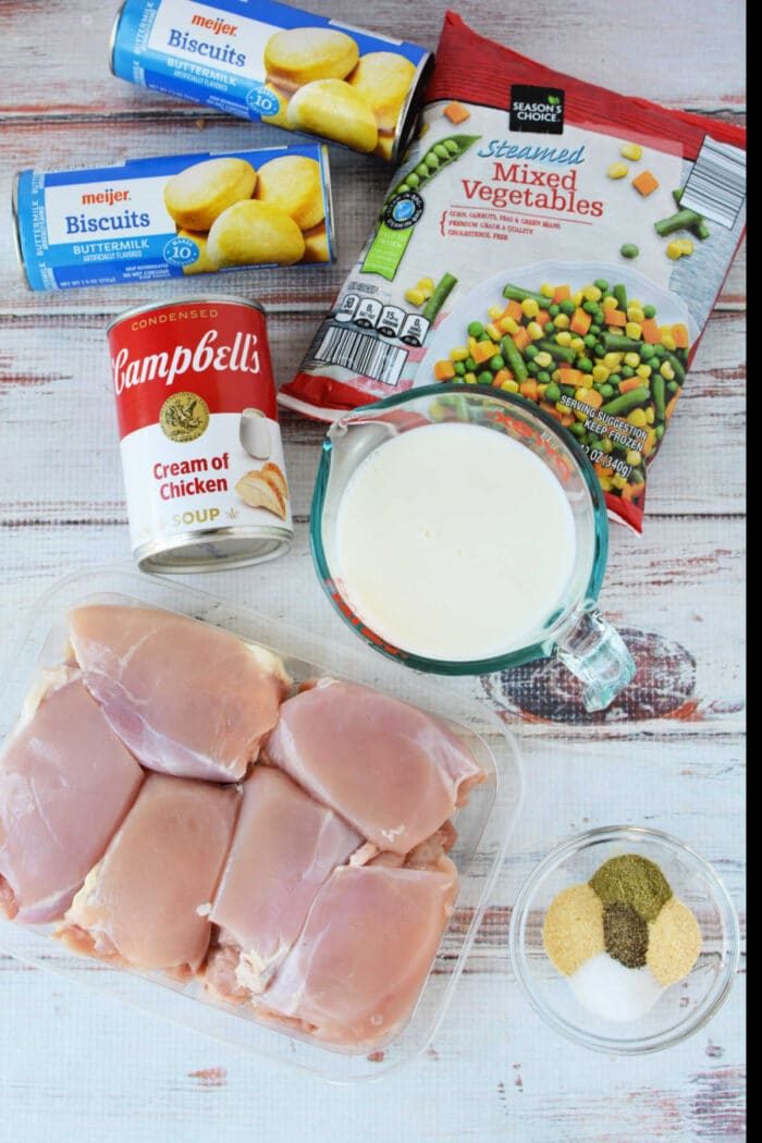 Ingredients for a Chicken Pot Pie casserole: biscuits, frozen mixed vegetables, cream of chicken soup, milk, chicken, and spices—solid for baking or making in your Crockpot.