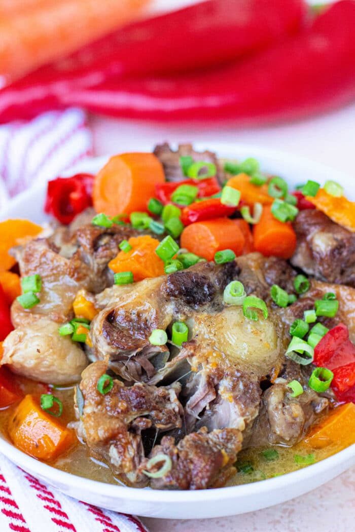 Stewed easy oxtail recipe, garnished with fresh scallions.
