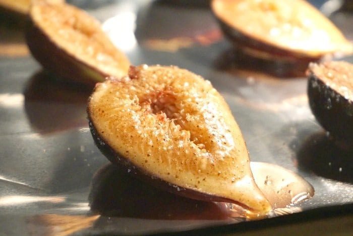 Close-up of roasted pear halves with a sprinkle of brown sugar on a baking sheet, reminiscent of how to bake figs in the oven.