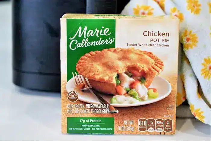 A Marie Callender's Chicken Pot Pie box is shown in the image, solid for a quick meal in an air fryer. The packaging highlights tender white meat chicken, 17g of protein, and no preservatives or artificial flavors, while offering a clear view of the product's nutritional information.