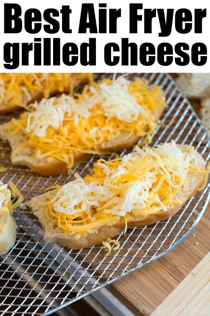 Open-faced bread slices topped with shredded cheese are arranged on an air fryer rack, solid for making grilled cheese in air fryer style.