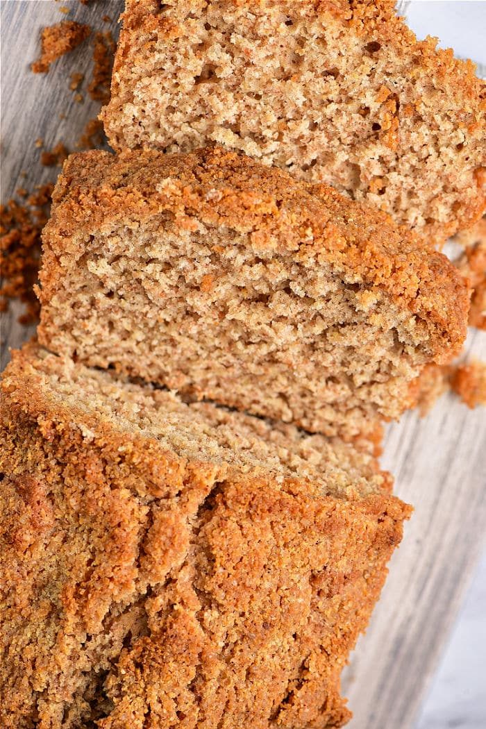 A sliced loaf of healthy coffee cake loaf rests on a wooden surface, effortlessly combining the comforting flavors of a healthy coffee cake.