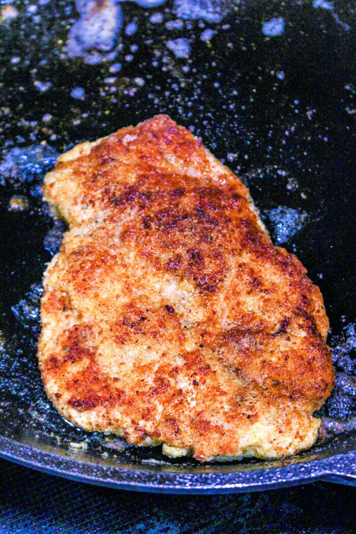 Golden brown breaded chicken frying in a black pan with oil bubbling around it, offering a mouthwatering aroma thats hard to resist. While frying creates that crisp crust, for those wondering how long to bake chicken cutlets instead, the oven method ensures juicy tenderness inside.