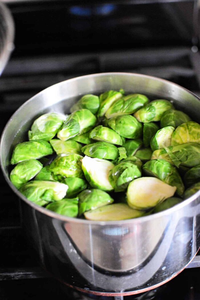Brussels sprouts simmer gently in a stainless steel pot on the stovetop, filling the kitchen with their earthy aroma. Wondering how long to boil Brussels sprouts for solid tenderness? Aim for about 8-10 minutes.