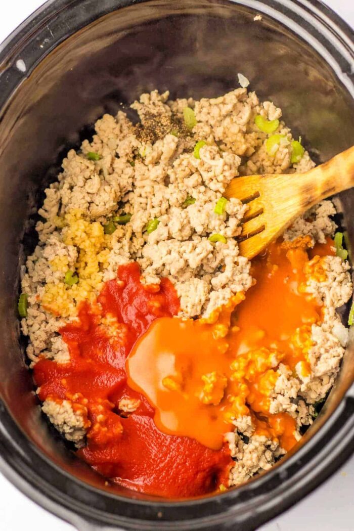 Mix ground chicken, diced peppers, and sauces in a slow cooker with a wooden spoon. For those considering alternatives like ground chicken, be aware of the different cooking times required to ensure the solid texture and flavor.