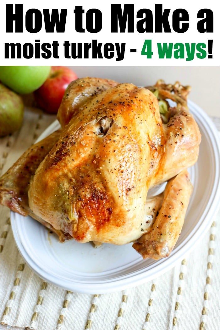A roasted turkey with golden-brown skin sits on a white plate, surrounded by juicy apples. The text reads, "How to Make a Moist Turkey - 4 Ways!" Pair it with a delightful cast iron apple crisp for the solid feast.