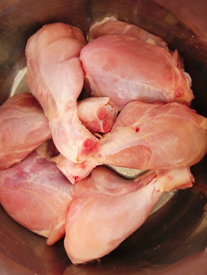 Raw chicken legs, sit in a metal bowl, ready for instant pot cooking or preparation.