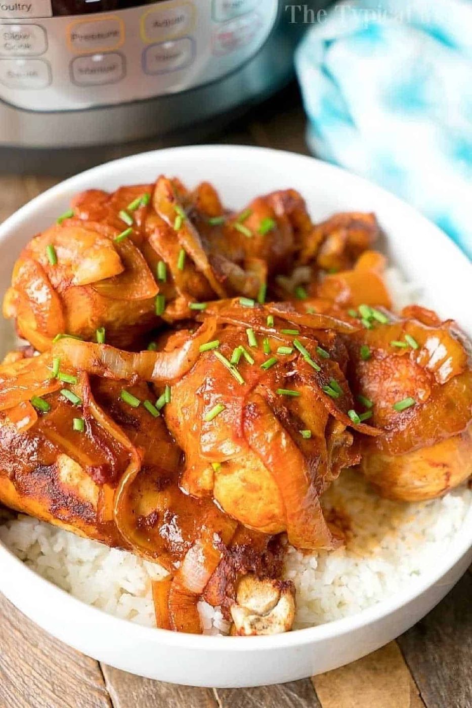 Instant Pot chicken legs cooked with onions and savory sauce, served over white rice in a bowl, with an Instant Pot in the background.