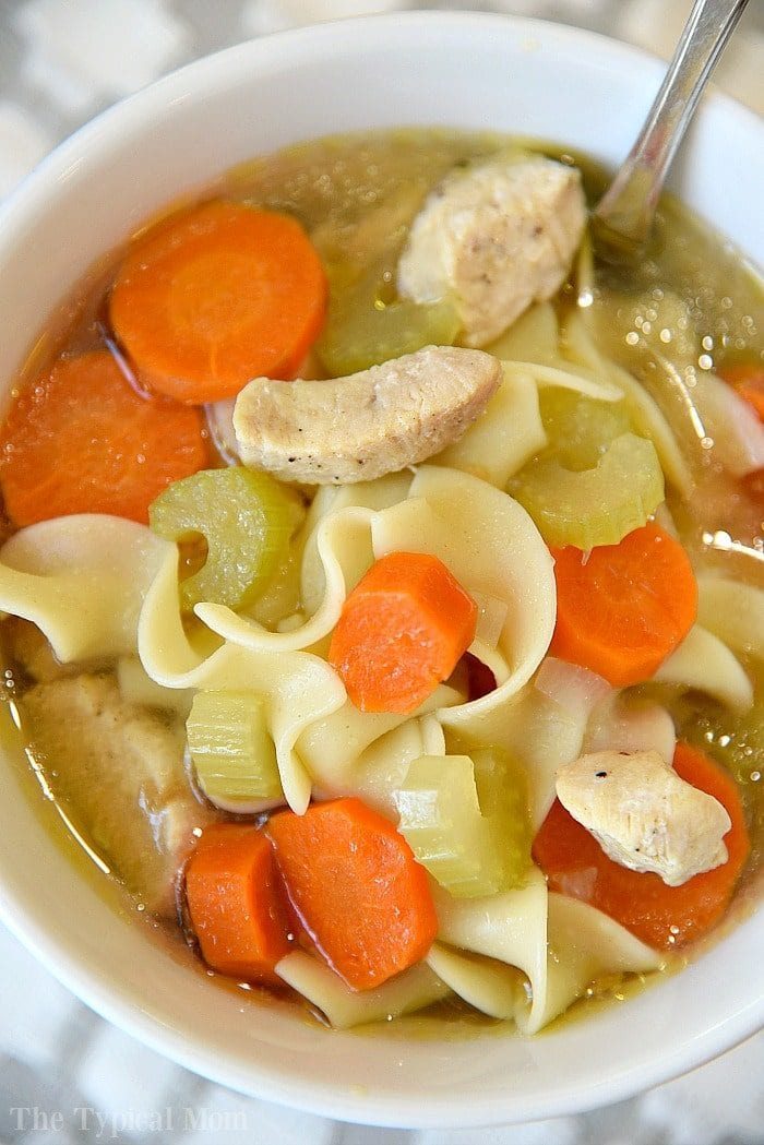 A bowl of comforting Instant Pot chicken noodle soup with carrots and celery, served with a spoon.