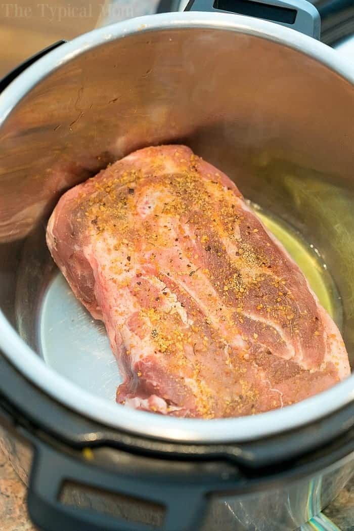 Seasoned raw pork roast in an electric pressure cooker, solid for making flavorful Asian Instant Pot Pulled Pork.