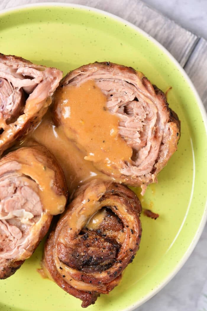 Savor the taste of rolled lamb breast with sauce, artfully presented on a green plate. For those intrigued by variety, this dish pairs beautifully with our Lamb Breast Recipe, offering a delightful blend of flavors that's sure to please your palate.