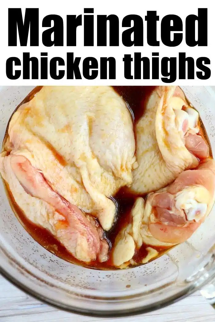 Raw chicken thighs in a glass bowl soaking in dark marinade, highlighted by bold text reading Marinated chicken thighs—solid for making good marinated chicken in air fryer meals.