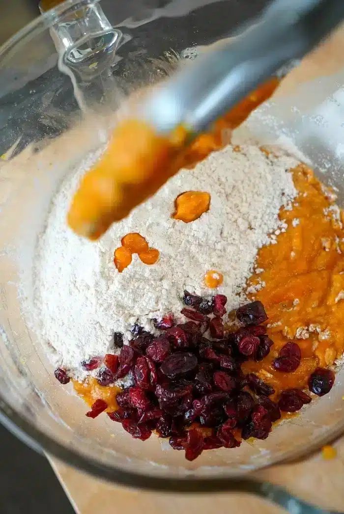 Mixing bowl with flour, cranberries, and rich pumpkin puree—solid for crafting moist pumpkin bread delights.