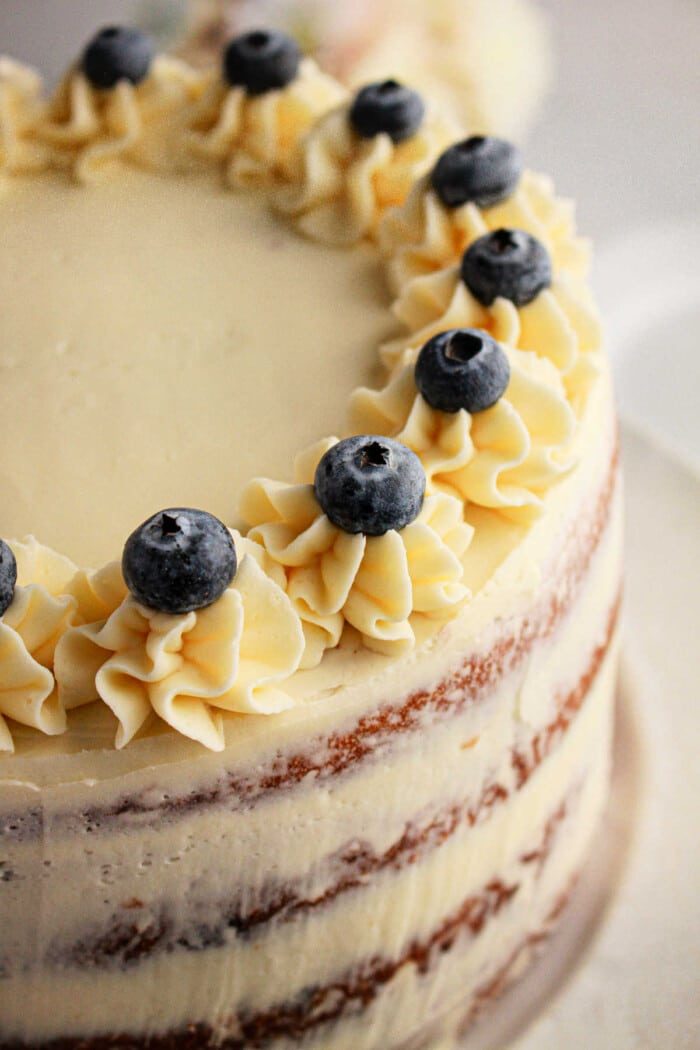 A luscious cake crafted with muffin mix, topped with frosted blueberries and cream decorations.