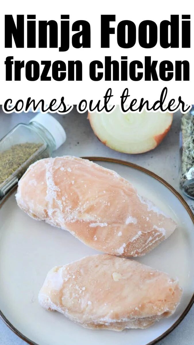 Two frozen chicken breasts on a plate with seasonings and an onion in the background—solid ingredients for quick and tasty Ninja pressure cooker recipes.