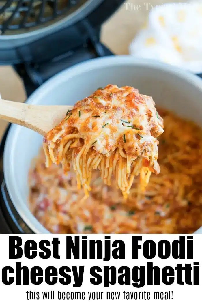A wooden spoon lifts cheesy spaghetti from a pot, with melted cheese and sauce visible—a good example of ninja pressure cooker recipes.