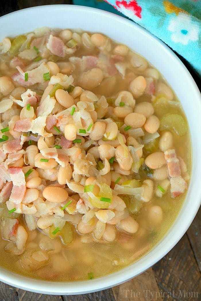 A bowl of pressure cooker white bean soup with bacon and green onions, topped with chives.