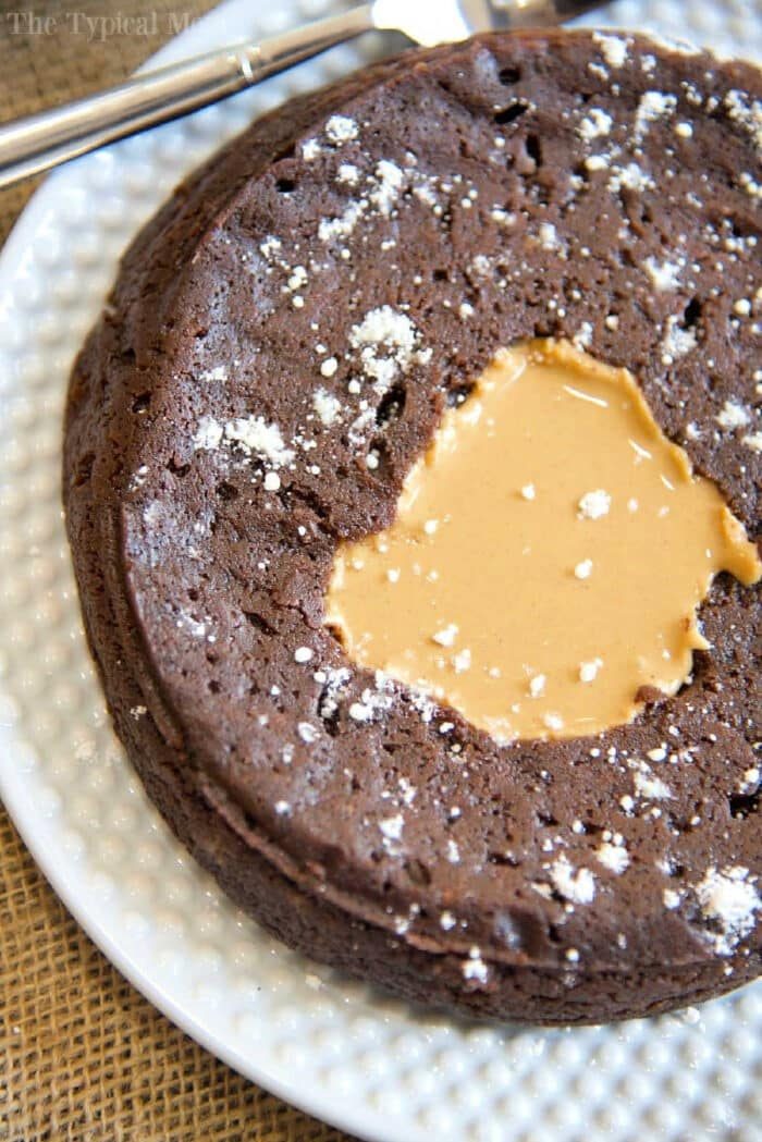 pressure cooker brownie with a melted peanut butter center, sprinkled with powdered sugar on a white plate—solid for fans of pressure cooker brownies seeking a quick, decadent treat.