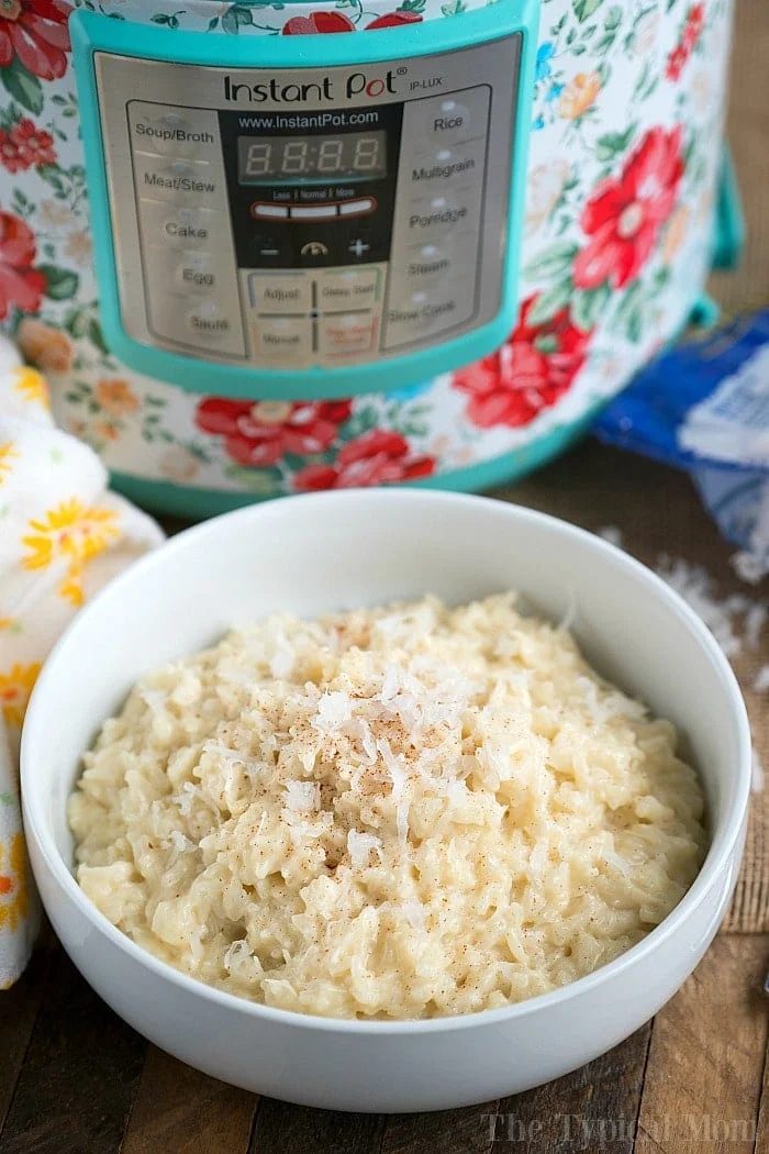 A bowl of coconut rice pudding sits elegantly in front of a floral-patterned Instant Pot, reminiscent of a delectable instant pot rice pudding recipe.