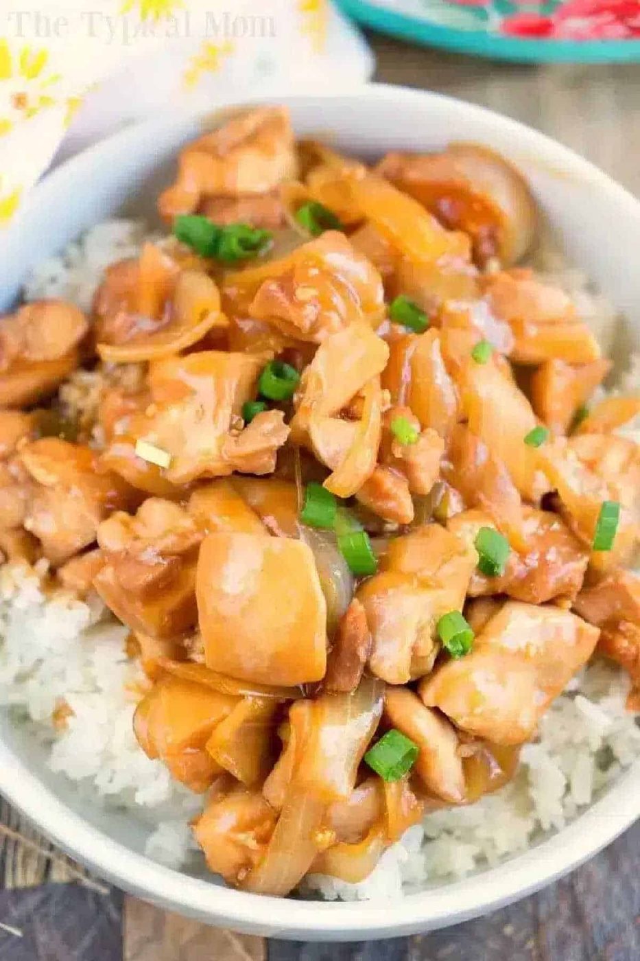 Bowl of hoisin chicken with chopped green onions served over white rice.